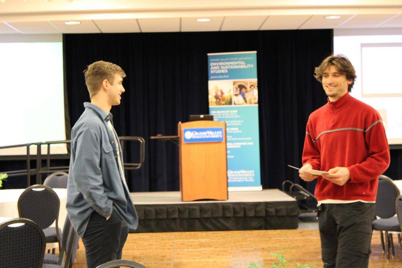 two students talking in the Grand River room at the showcase